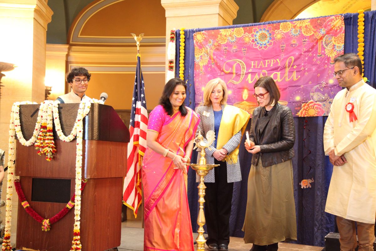 L-R-AIA-Diwali-Coordinator-Peggy-Flanagan-Rep-Robbins-Lt-Governor-Flanagan-with-HSMN-Chair-Ganesh-Ram-lighting-of-the-traditional-Diwali-lamp-upl.jpg